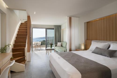 萨尔蒂Exclusive Villas Pappas的一间带大床和楼梯的卧室