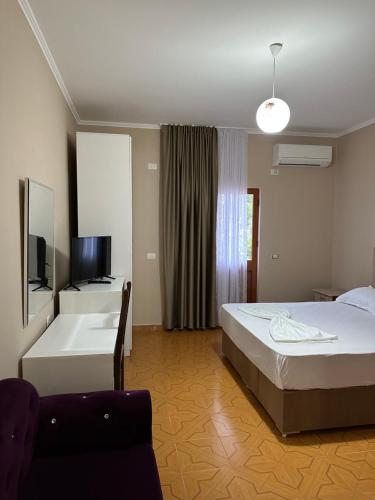圣金Molla Hotel Restorant的一间卧室配有一张床、一个浴缸和一台电视。