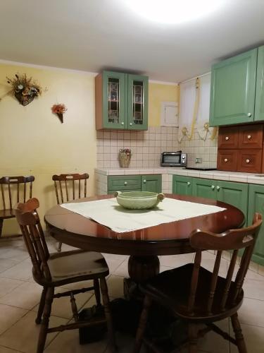 恩纳Apartment Maria的厨房配有绿色橱柜和桌椅