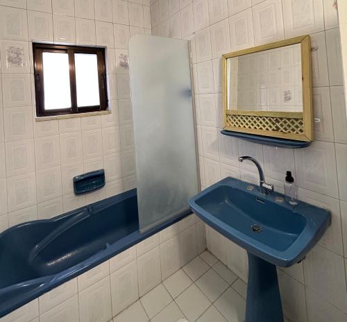 安曼Crafthouse的浴室设有蓝色水槽和镜子