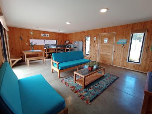 阿尔加罗沃7 Olas lodge的客厅配有蓝色的沙发和桌子
