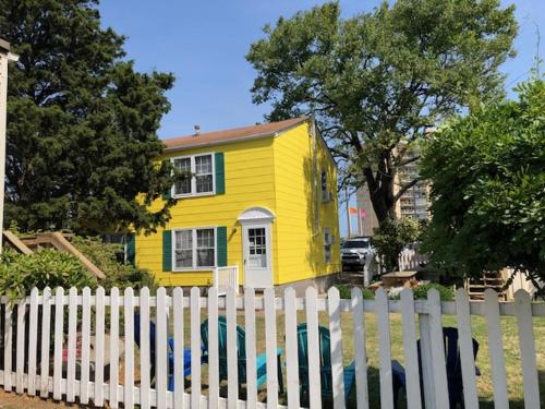 弗吉尼亚海滩Cutty Sark Efficiencies and Historic Cottage's的白色围栏后面的黄色房子