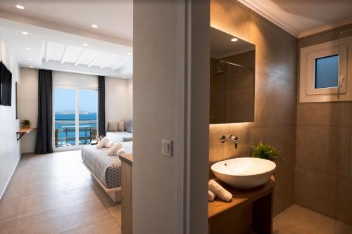 米克诺斯城Magic View Suites Mykonos的一间带水槽的浴室和一间带一张床的卧室
