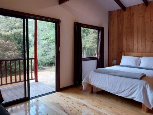 CopeyCuruba Lodge的一间卧室设有一张床和一个滑动玻璃门