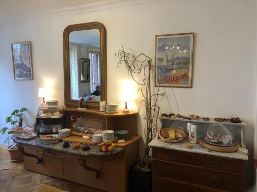 埃维昂莱班Hôtel Continental的一间带镜子的梳妆台和梳妆台的房间