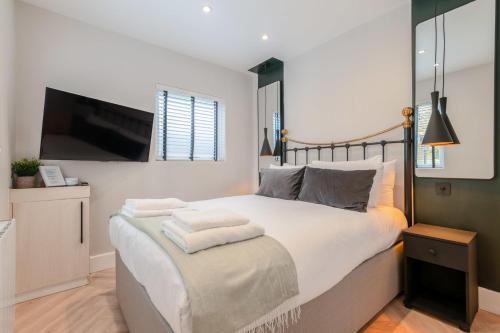 伦敦The Balham Hideaway的一间卧室设有一张大床和一台平面电视。