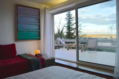 罗纳河畔的图尔农Casa mARTa : Suites, terrasses et vue panoramique的一间卧室设有大窗户,享有庭院的景色