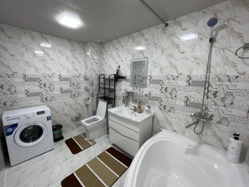 撒马尔罕Samarkand luxury apartment #5的浴室配有洗衣机、洗衣机和烘干机。