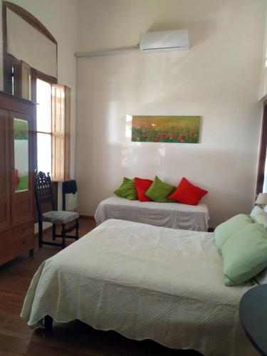 拉巴斯La Soñada的一间卧室配有两张带红色和绿色枕头的床