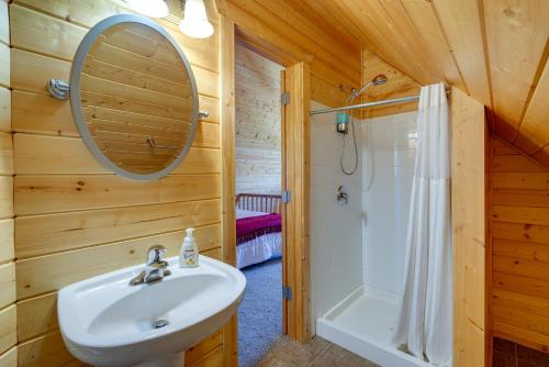 哥伦比亚Lakefront Columbia Cabin with Porch and Shared Dock的一间带水槽、淋浴和镜子的浴室