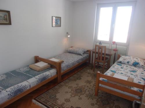 杜布罗夫尼克Rooms Port的带三张床、椅子和窗户的房间
