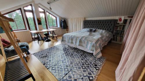 BooWonderful wooden house next to lake and Stockholm archipelago的卧室配有床、桌子和窗户。