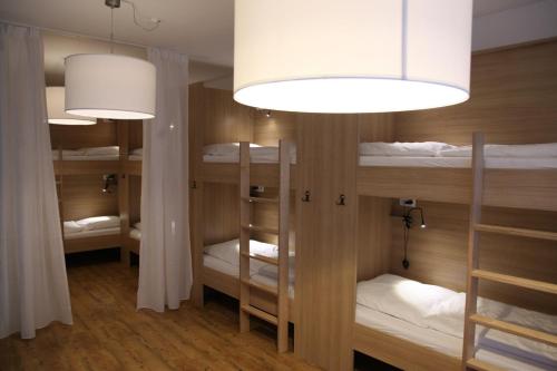 福森Old Kings Design Hostel的一间设有三张双层床和一盏灯的房间