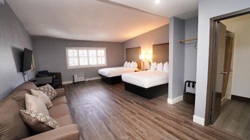 圣克鲁兹SeaSide Inn & Suites的酒店客房,设有两张床和一张沙发