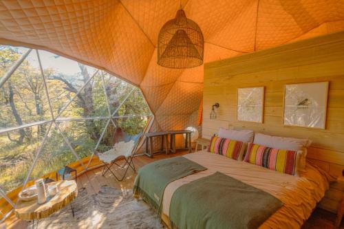 厄尔查尔坦Chalten Camp - Glamping with a view的一间卧室设有一张床和一个大窗户
