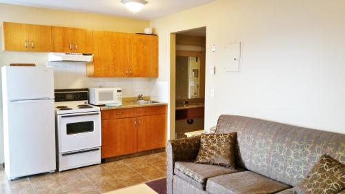 坎卢普斯高山汽车旅馆的带沙发和白色冰箱的厨房