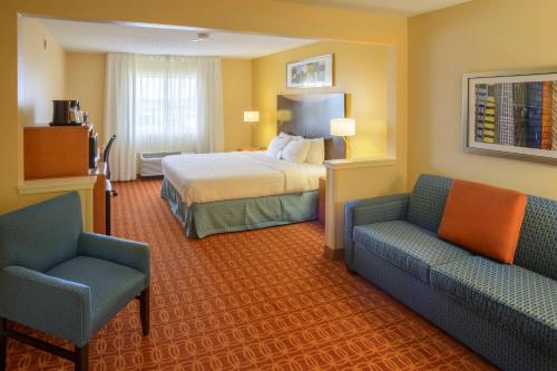 印第安纳波利斯印第安纳波利斯南费尔菲尔德客栈的酒店客房,配有一张床和两把椅子