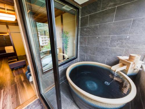 日光LiVEMAX RESORT Kawaji的一间位于客房内的带大型蓝色浴缸的浴室
