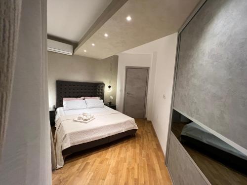 斯科普里Maria's Elite Luxury Apartment Skopje的一间卧室配有一张铺有木地板的白色床单。