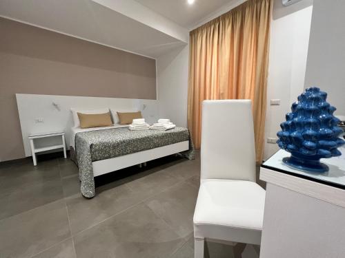 特罗佩阿Anfitrite B&B Tropea的一间卧室配有一张床和一张白色椅子