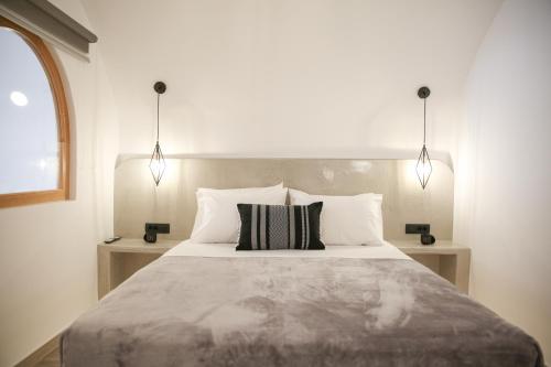 安坡里奥圣托里尼Luxury Canava的一间卧室配有一张大床和两盏灯