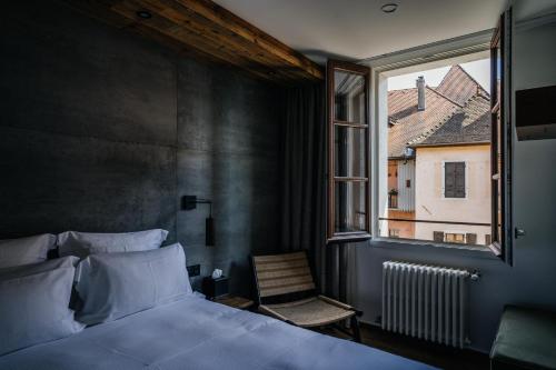 安锡Auberge du Lyonnais的一间卧室设有一张床、一个窗口和一把椅子