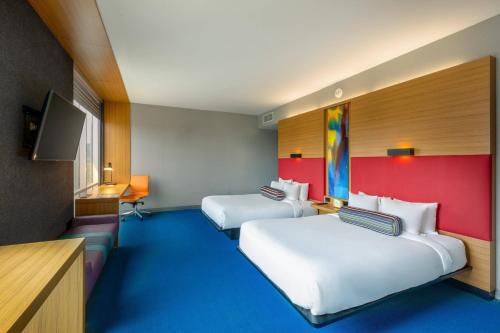 圣何塞Aloft San Jose Hotel, Costa Rica的一间酒店客房,设有两张床和电视