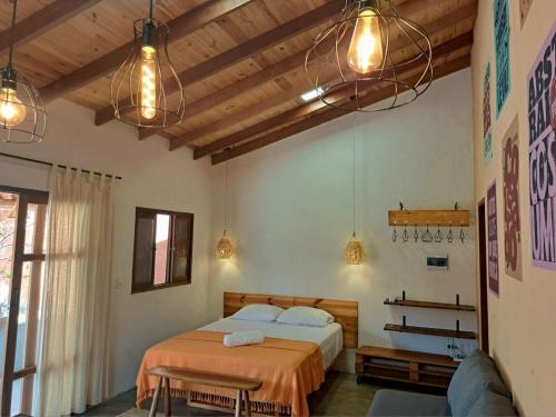圣若热岛Casa Om - Vila de São Jorge的一间卧室配有两张床、灯和一张沙发