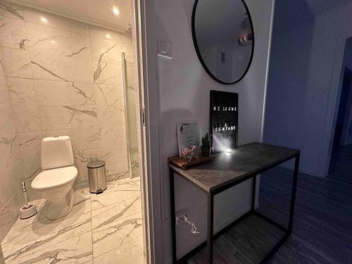 埃斯基尔斯蒂纳Modernt & rymligt sommarhus på landet- Bubbelpool的浴室设有卫生间和墙上的镜子。