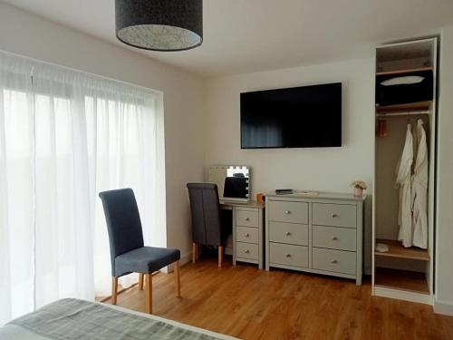 基斯高地Flotnar Hús - Ensuite Rooms的一间卧室配有两把椅子和一张书桌及电视