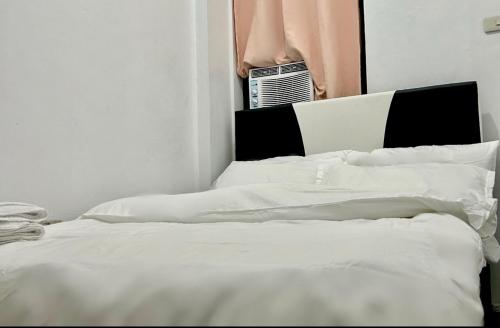 马尼拉Private room with AC and fan at EKG House Rental的一间卧室设有两张白色的床和窗户