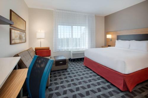 尼斯维尔TownePlace Suites by Marriott Niceville Eglin AFB Area的酒店客房带一张大床和一把椅子