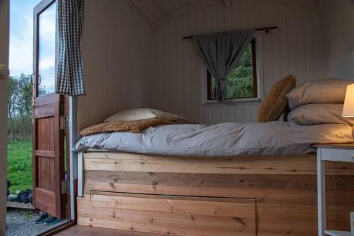 卡迪夫Shepherds Hut in enclosed field的木平台上的一张床位