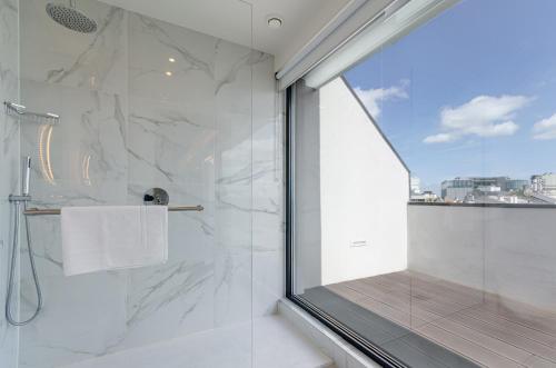 里斯本OMID Saldanha Hotel的带淋浴的浴室和玻璃窗