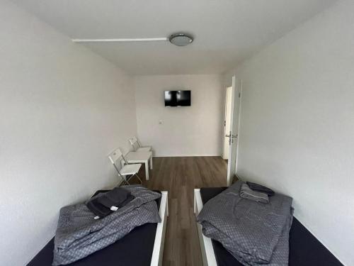 不莱梅Zimmervermietung Am Airport的客房设有两张床和一台墙上的电视。