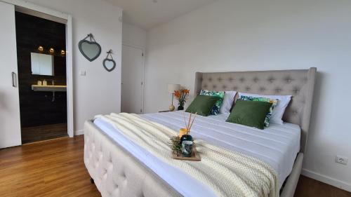 大里贝拉Magnolia Residence - In the Center of the Island的卧室配有带绿色枕头的大型白色床