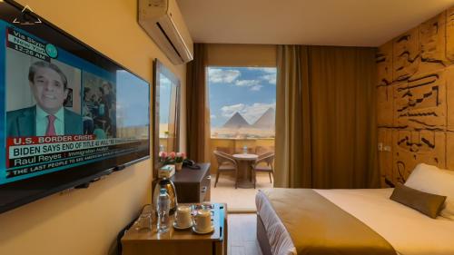 开罗Celia Pyramids View inn的配有一张床和一台平面电视的酒店客房