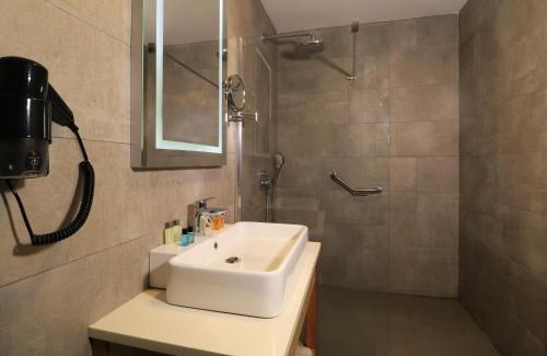 特拉布宗Ramada By Wyndham Vakfıkebir的浴室配有白色水槽和淋浴。