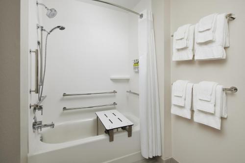 微风湾Holiday Inn Express & Suites Gulf Breeze - Pensacola Area, an IHG Hotel的带淋浴、浴缸和毛巾的浴室