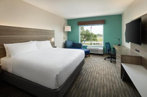 微风湾Holiday Inn Express & Suites Gulf Breeze - Pensacola Area, an IHG Hotel的酒店客房,配有床和电视