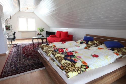 莱茵河畔威尔朗比主教宫酒店的一间卧室配有一张大床和一张红色椅子