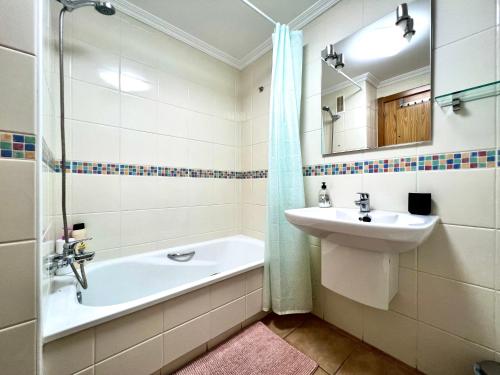 拉特吉塔Apartment in La Tejita (El Medano)的浴室配有盥洗盆、浴缸和镜子
