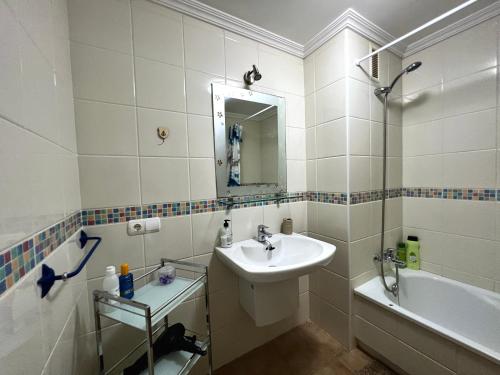 拉特吉塔Apartament with Garden的白色的浴室设有水槽和浴缸。