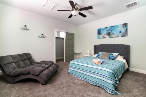 圣安东尼奥Casa Dolce Vita by the Alamodome的一间卧室配有一张床、一张沙发和吊扇。