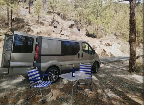 大加那利岛拉斯帕尔马斯Autocaravana Camper的停放在桌椅旁的面包车