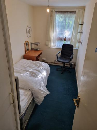 伦敦6 Greville Court的客房设有两张床、一张桌子和一把椅子。