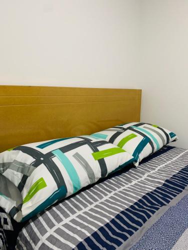 波哥大Bogotá Kings 302的一张带木制床头板和枕头的床