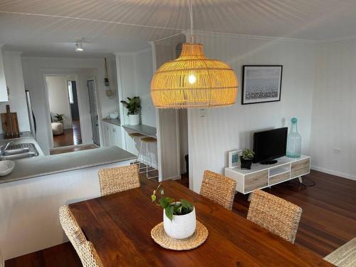 卡伦德拉Beach House @ Moffat的客厅配有桌椅和电视。