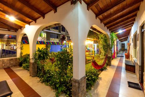 巴尼奥斯Santa Cruz Backpackers Hostal的一座室内花园,位于一座拥有拱门和植物的建筑中