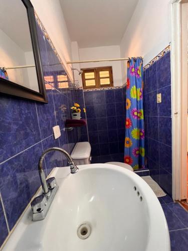 PampatarUn rinconcito en Pampatar的浴室设有白色浴缸和蓝色的淋浴帘